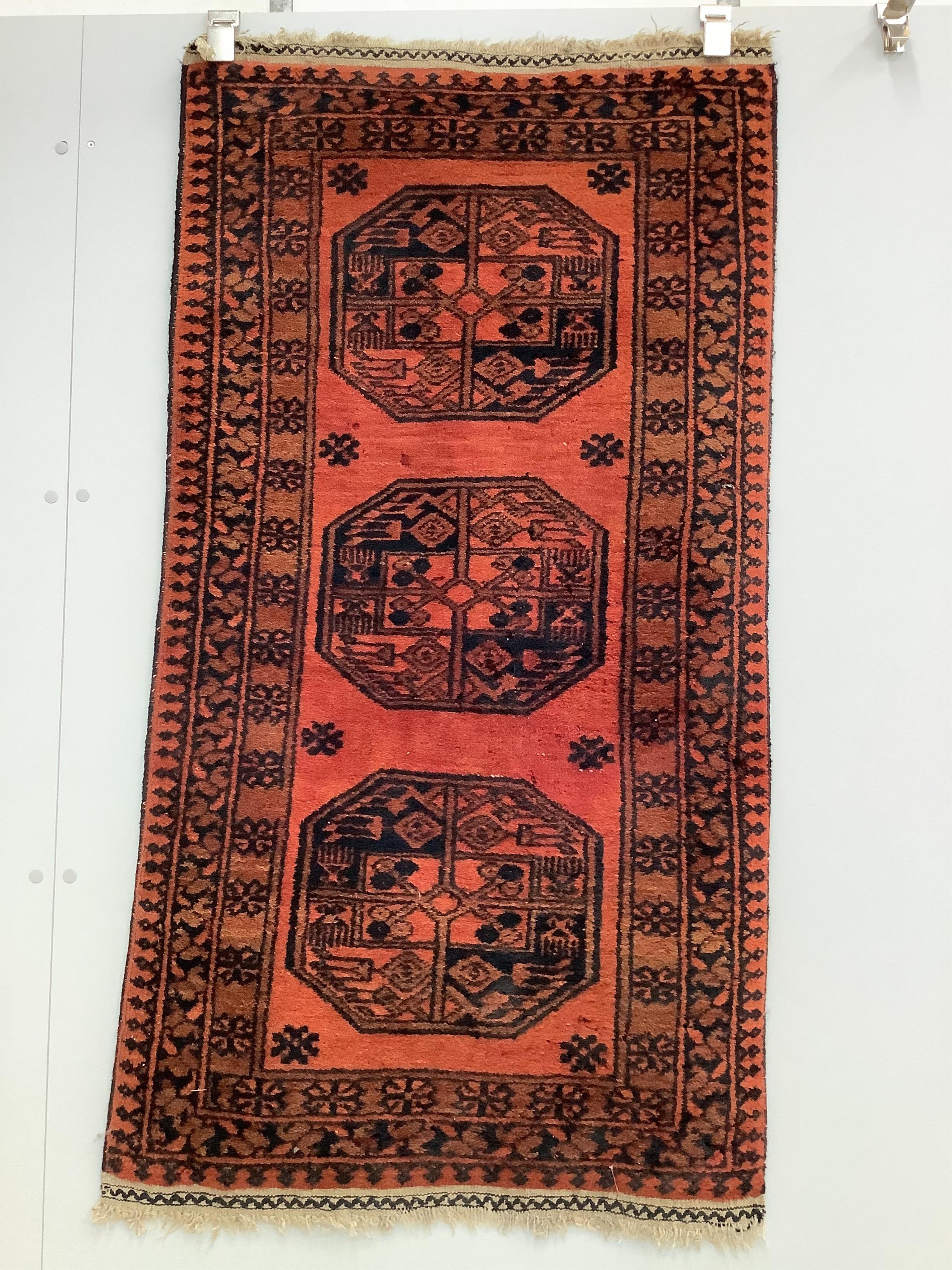 A pair of Afghan red ground rugs, each 144 x 75cm. Condition - fair
